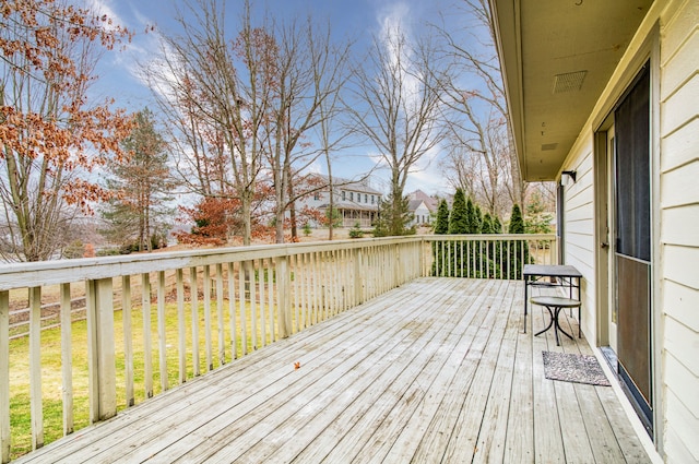 wooden terrace featuring a lawn