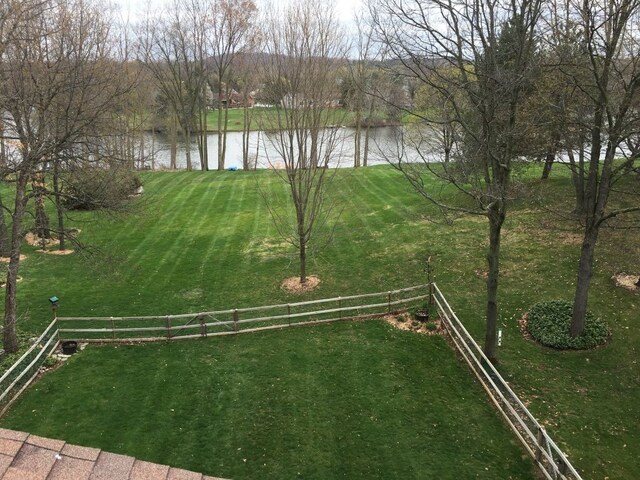 view of yard with a water view and fence