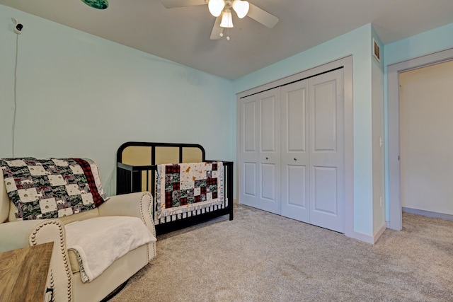 carpeted bedroom with ceiling fan, a closet, visible vents, and baseboards