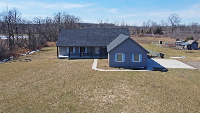 view of front of house featuring roof with shingles, a porch, and a front yard