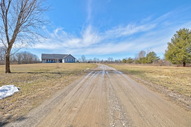 view of road with driveway and a rural view