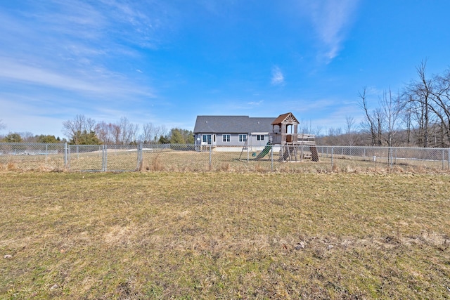 view of yard featuring a fenced backyard, a playground, and a rural view