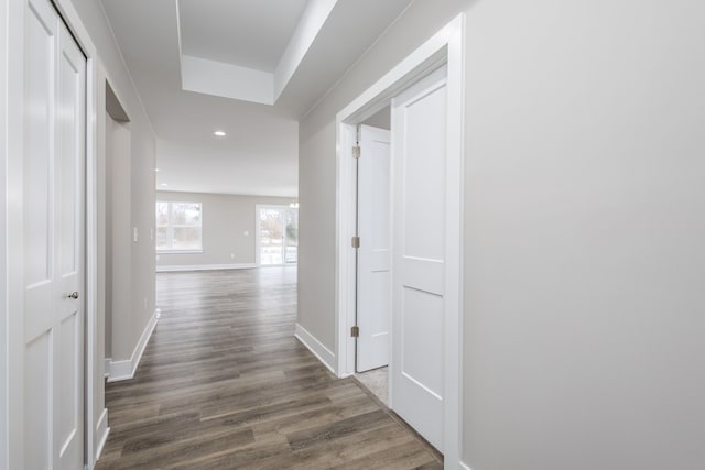 hallway featuring dark wood-type flooring, recessed lighting, and baseboards