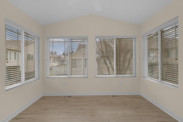 unfurnished room featuring light wood-style floors, vaulted ceiling, baseboards, and ceiling fan