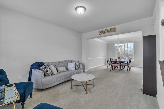 living room featuring an inviting chandelier, baseboards, carpet flooring, and ornamental molding