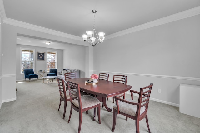 dining room with light carpet, crown molding, baseboards, and an inviting chandelier