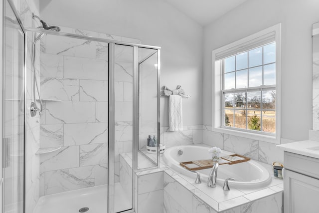 full bath featuring a marble finish shower, a bath, and vanity