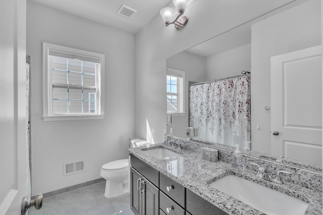 bathroom featuring toilet, visible vents, and a sink