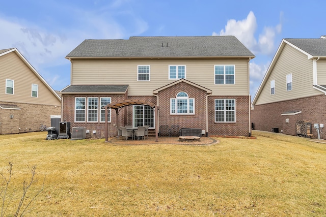 back of property with a shingled roof, a lawn, cooling unit, a patio area, and brick siding