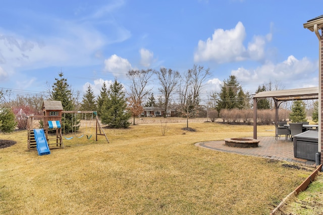 view of yard with a fire pit, a playground, and a patio