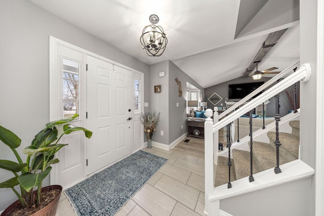 foyer entrance with vaulted ceiling with beams, stairs, baseboards, and ceiling fan with notable chandelier