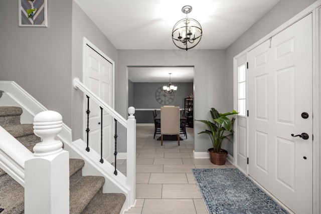 entryway featuring stairs, light tile patterned floors, baseboards, and a notable chandelier