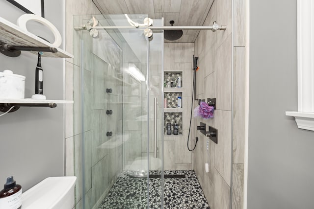 bathroom featuring a shower stall and toilet