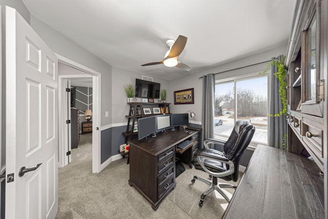 office area with baseboards, a ceiling fan, and light colored carpet