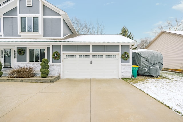 view of front of house with a garage, concrete driveway, and brick siding