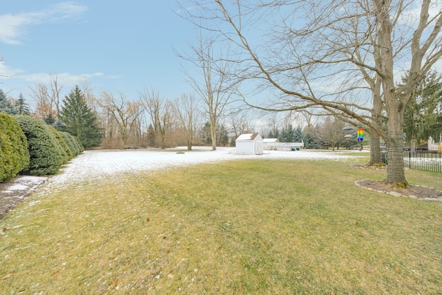 view of yard featuring an outdoor structure, fence, and a shed