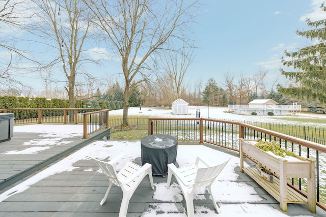 deck featuring an outdoor structure, fence, and a storage unit