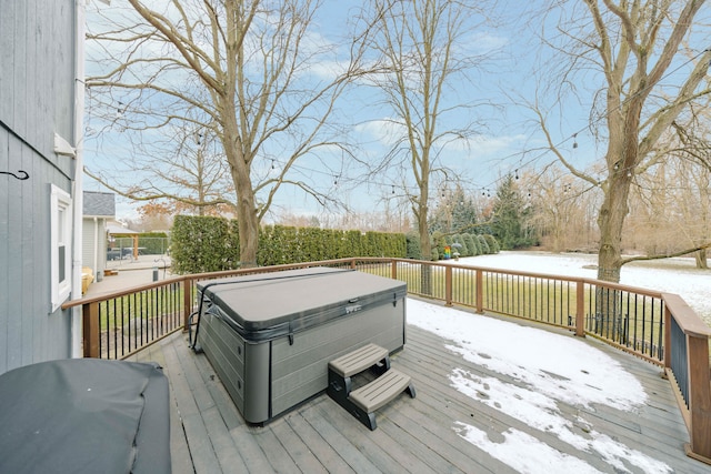 snow covered deck with a hot tub and area for grilling