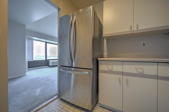 kitchen with light carpet, white cabinetry, baseboards, light countertops, and freestanding refrigerator