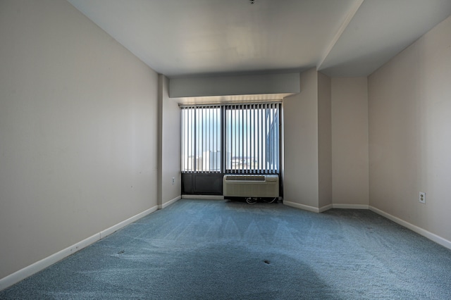 spare room with carpet floors, an AC wall unit, and baseboards