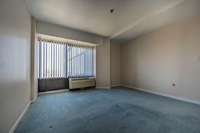 carpeted spare room with an AC wall unit and baseboards