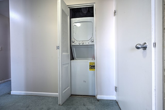 clothes washing area with stacked washer and dryer, carpet, laundry area, and baseboards