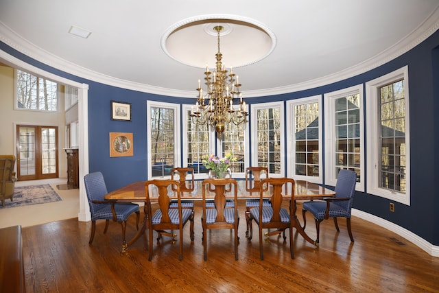 dining area with visible vents, a notable chandelier, wood finished floors, and ornamental molding