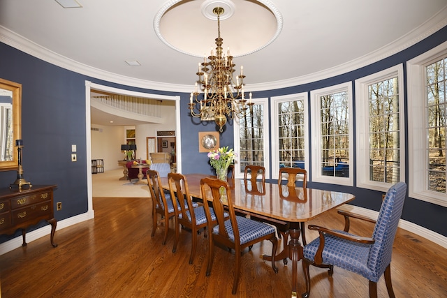 dining room with wood finished floors, an inviting chandelier, and ornamental molding