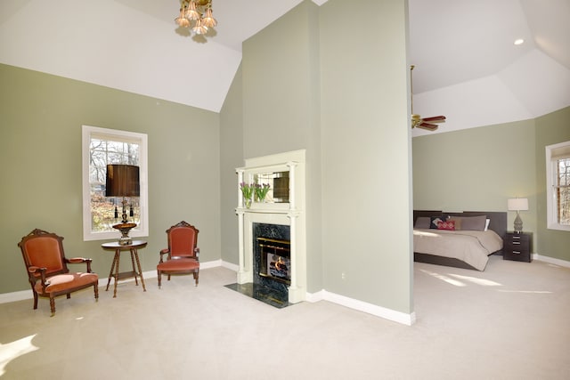 sitting room with high vaulted ceiling, carpet flooring, baseboards, and a premium fireplace