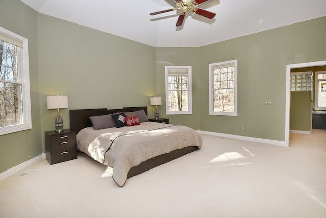 bedroom with visible vents, lofted ceiling, a ceiling fan, baseboards, and light colored carpet