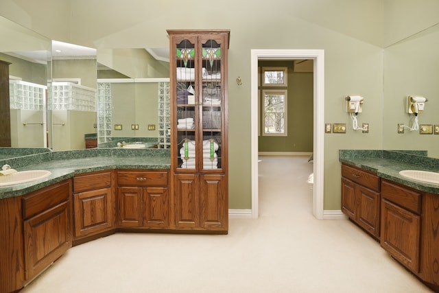 bathroom featuring vanity, a shower stall, and baseboards