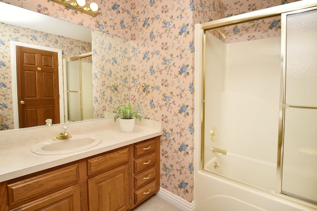 bathroom featuring combined bath / shower with glass door, wallpapered walls, vanity, and baseboards