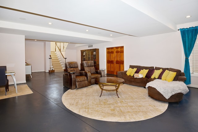 living area featuring baseboards, visible vents, recessed lighting, finished concrete floors, and stairs