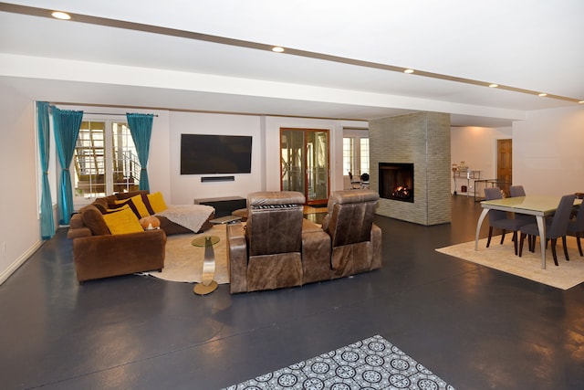 living room with recessed lighting, finished concrete flooring, a multi sided fireplace, and a wealth of natural light