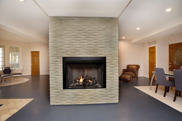 interior space featuring recessed lighting, visible vents, concrete flooring, and a tile fireplace