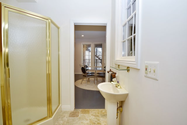 bathroom featuring a stall shower and stone finish flooring