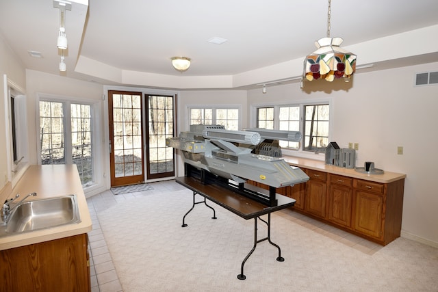 home office featuring a raised ceiling, visible vents, and a sink