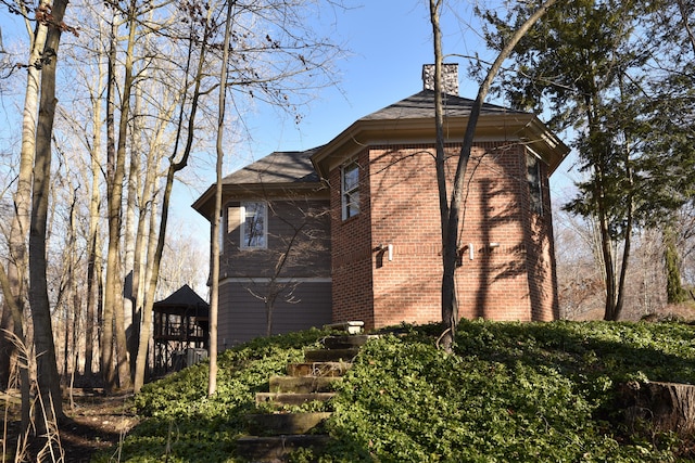 view of side of property with brick siding and a chimney