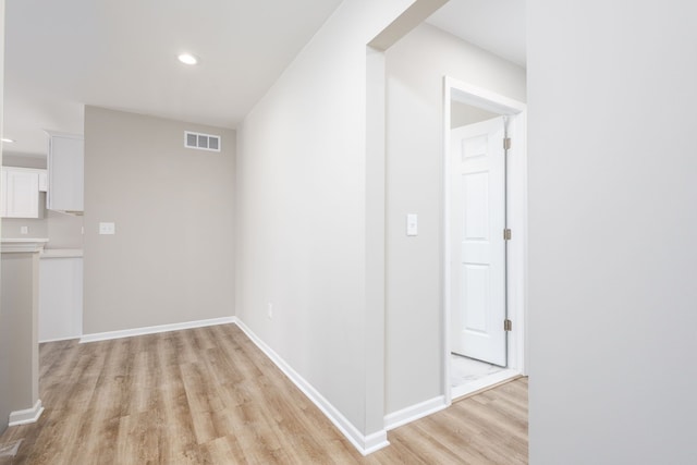 hall with light wood finished floors, recessed lighting, visible vents, and baseboards