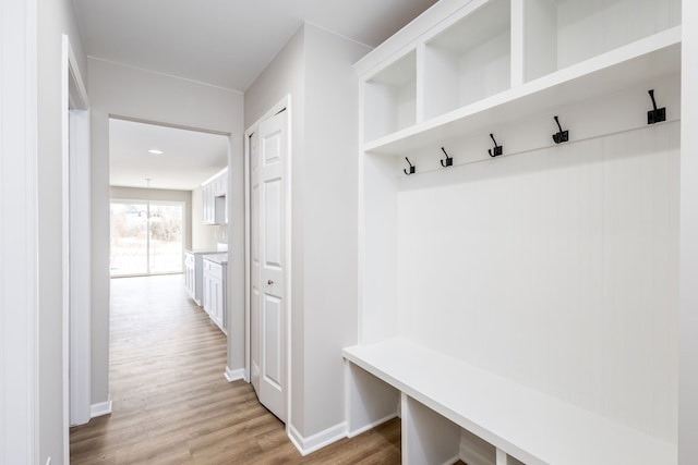 mudroom featuring light wood finished floors, an inviting chandelier, and baseboards