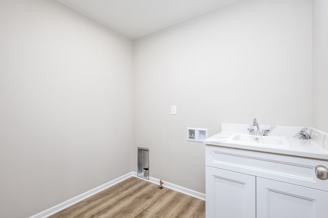 clothes washing area featuring hookup for a washing machine, light wood-style flooring, a sink, gas dryer hookup, and baseboards