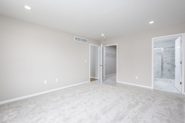 unfurnished bedroom with visible vents, baseboards, connected bathroom, light colored carpet, and recessed lighting