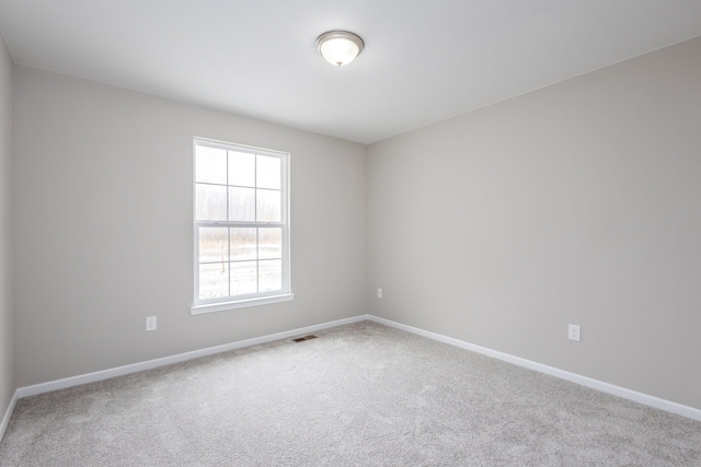 carpeted spare room with visible vents and baseboards