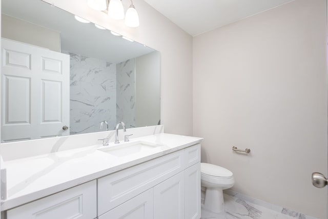 bathroom with marble finish floor, vanity, and toilet