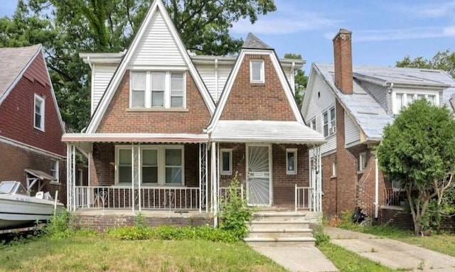 tudor house with covered porch and brick siding