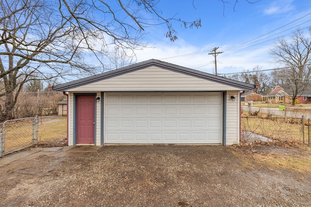 detached garage featuring fence and a gate