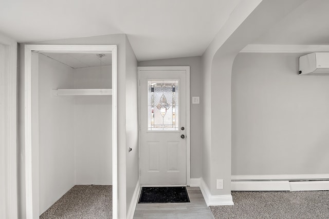 doorway to outside featuring baseboards, arched walkways, a baseboard radiator, wood finished floors, and a wall mounted AC