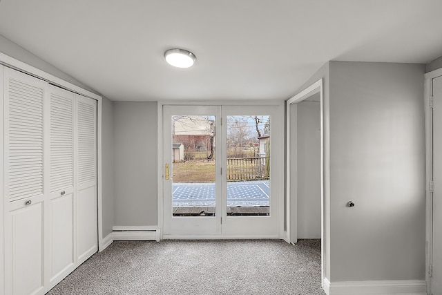 unfurnished bedroom featuring light carpet, a baseboard heating unit, access to exterior, and baseboards