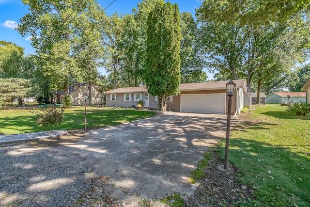 ranch-style home featuring a garage, concrete driveway, and a front lawn