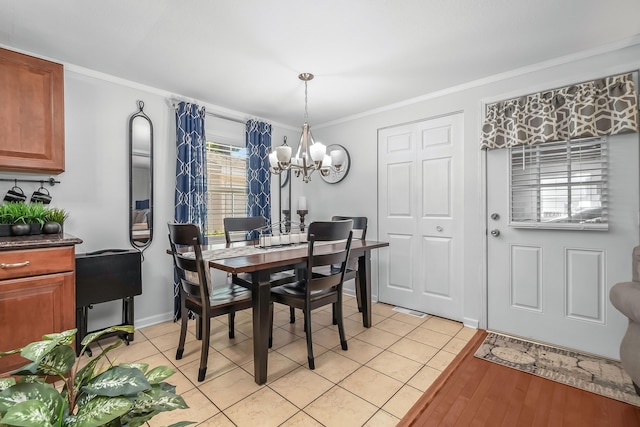 dining space featuring ornamental molding, a notable chandelier, baseboards, and light tile patterned floors